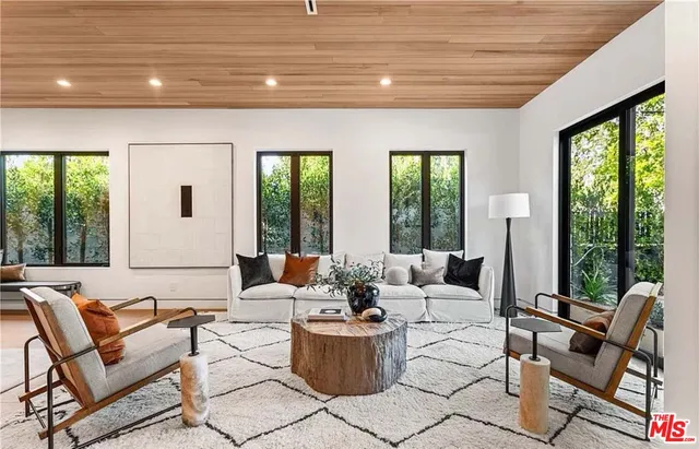 a living room with furniture and large windows