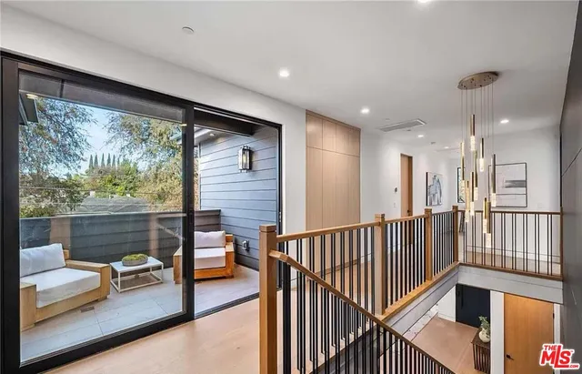 a view of a hallway with couches and dining table with wooden floor