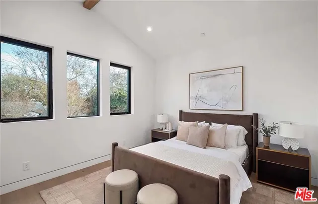 a bedroom with a bed and a painting on the wall