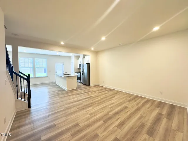 a view of a kitchen with wooden floor and a window