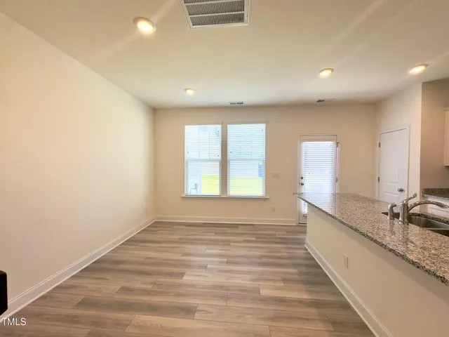 a hallway with a large mirror and a wooden floor