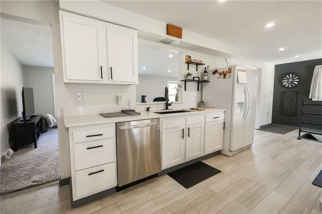 a kitchen with a sink cabinets and wooden floor