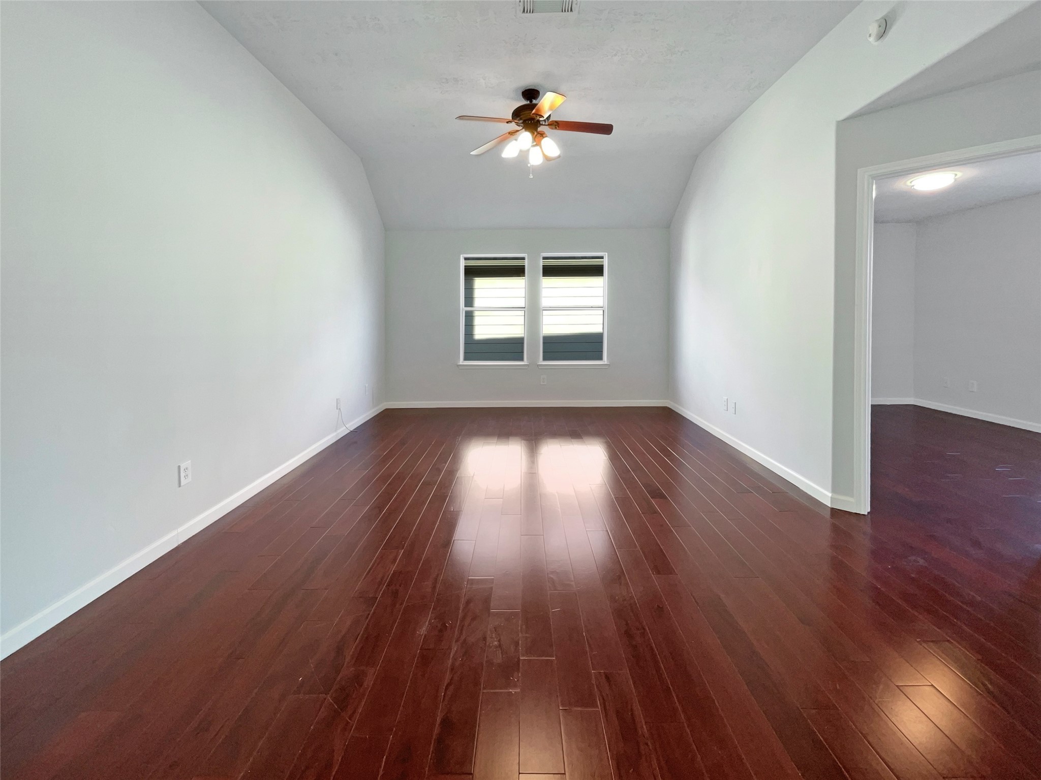 12111 Virline Lane Houston, TX 77067 - Photo 12 of 22 an empty room with wooden floor chandelier fan and windows