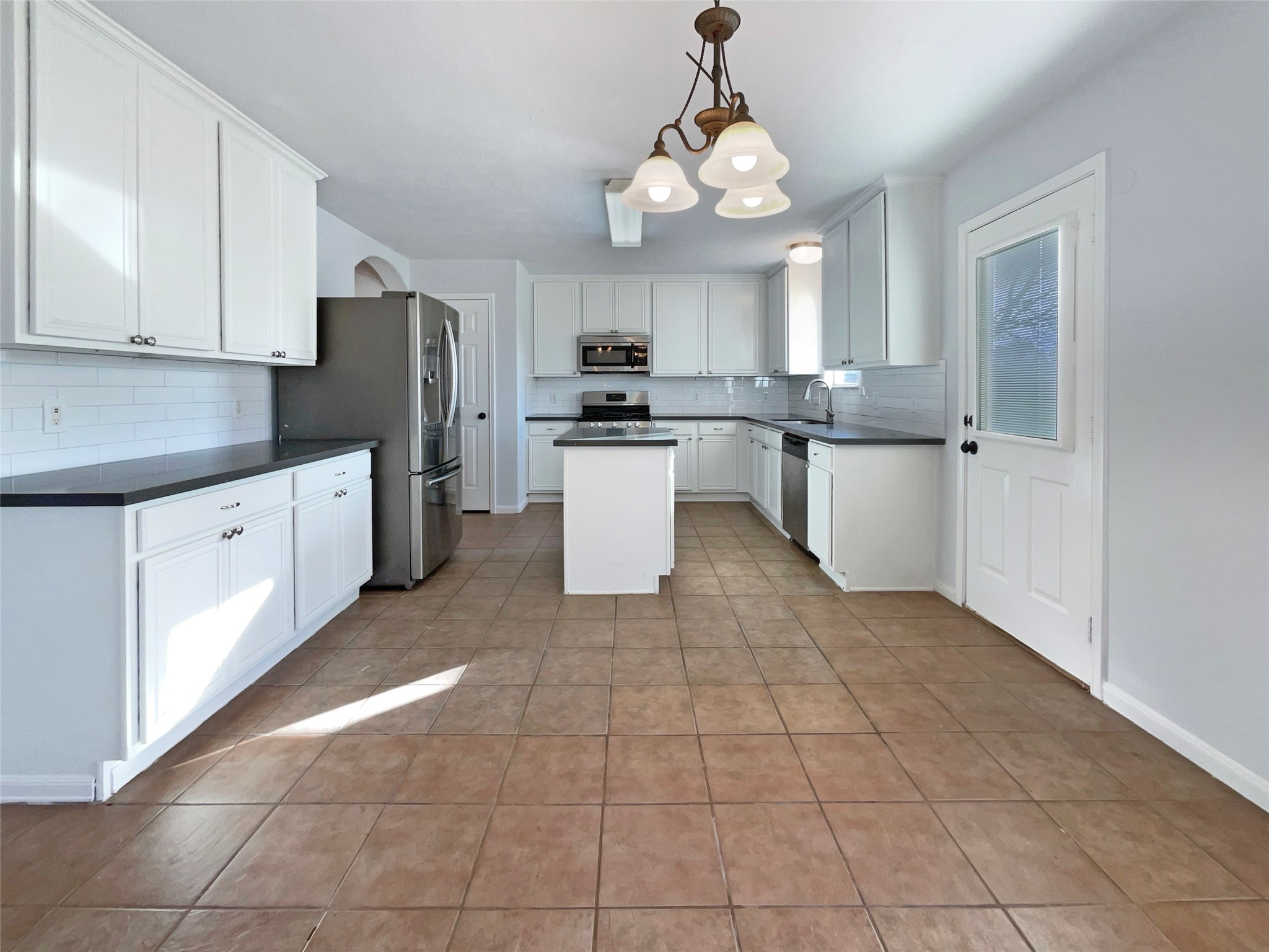 12111 Virline Lane Houston, TX 77067 - Photo 2 of 22 a kitchen with a refrigerator a sink and cabinets