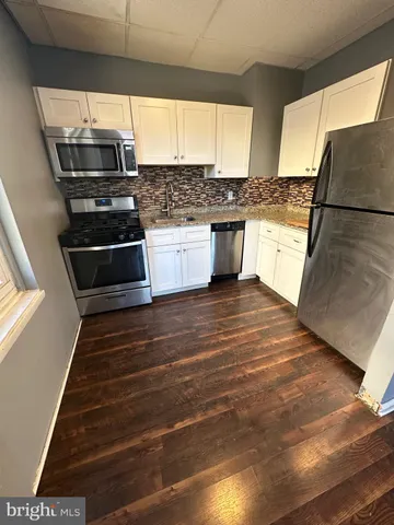 a kitchen with granite countertop a stove and a refrigerator
