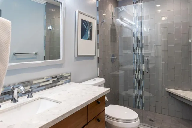 a bathroom with a sink a toilet and shower