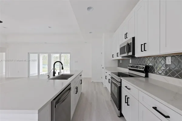 a kitchen with stainless steel appliances granite countertop a sink stove top oven and cabinets