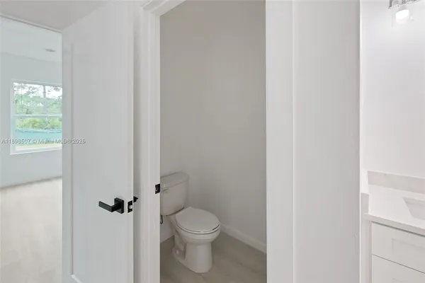 a bathroom with a granite countertop toilet and a sink