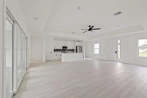 a view of empty room with wooden floor and window