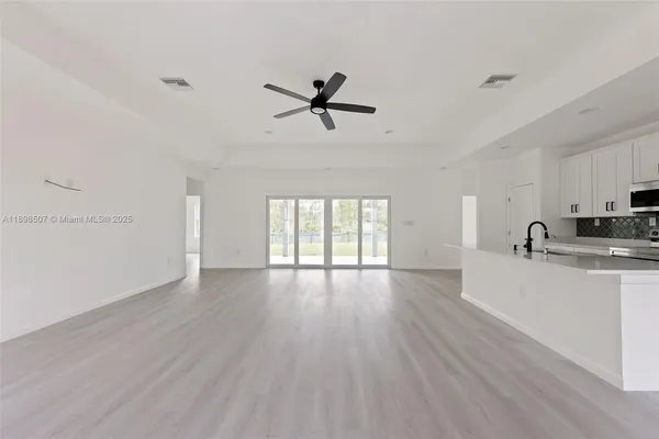 a view of a kitchen with a sink dishwasher a refrigerator and wooden floor