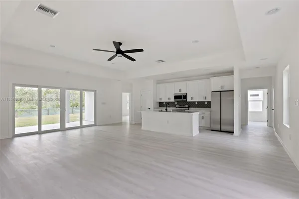 a view of an empty room with a kitchen