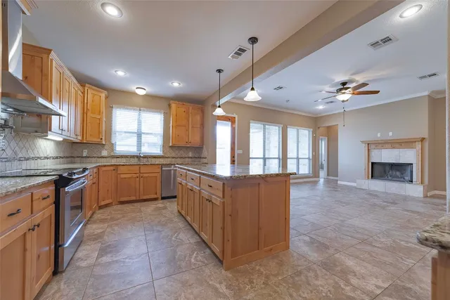 a kitchen with stainless steel appliances granite countertop a stove top oven a sink a counter space and cabinets