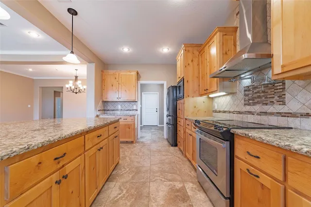 a large kitchen with stainless steel appliances granite countertop a stove a sink and a refrigerator