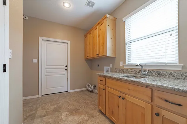 a bathroom with a granite countertop sink and a window