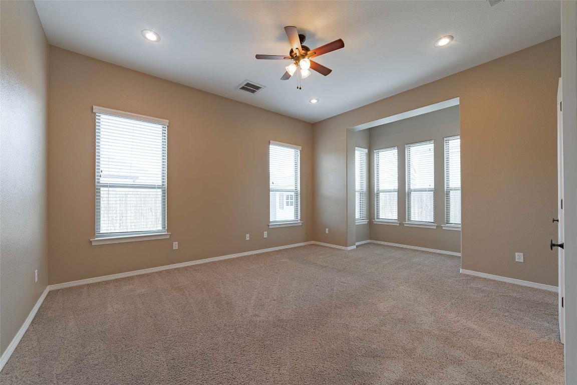 125 Walter Way Jarrell, TX 76537 - Photo 19 of 40 Empty room featuring light carpet, a ceiling fan, healthy amount of natural light, and recessed lighting