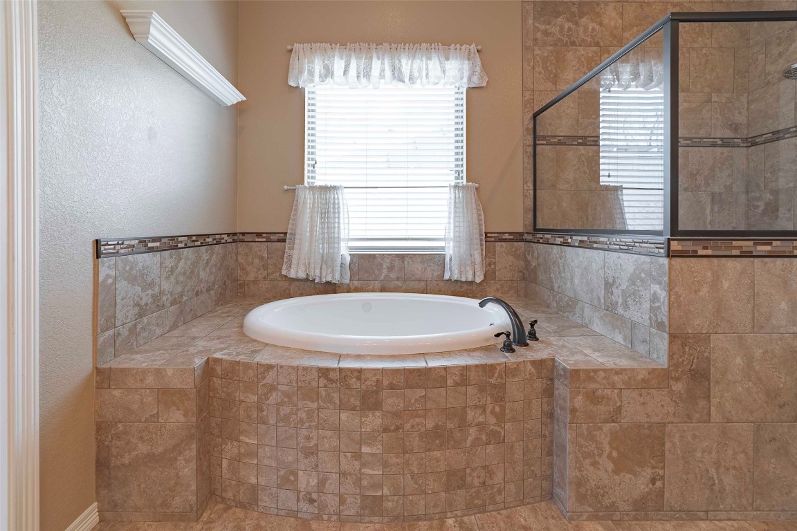 125 Walter Way Jarrell, TX 76537 - Photo 25 of 40 Bathroom with a bath, a tile shower, and a textured wall