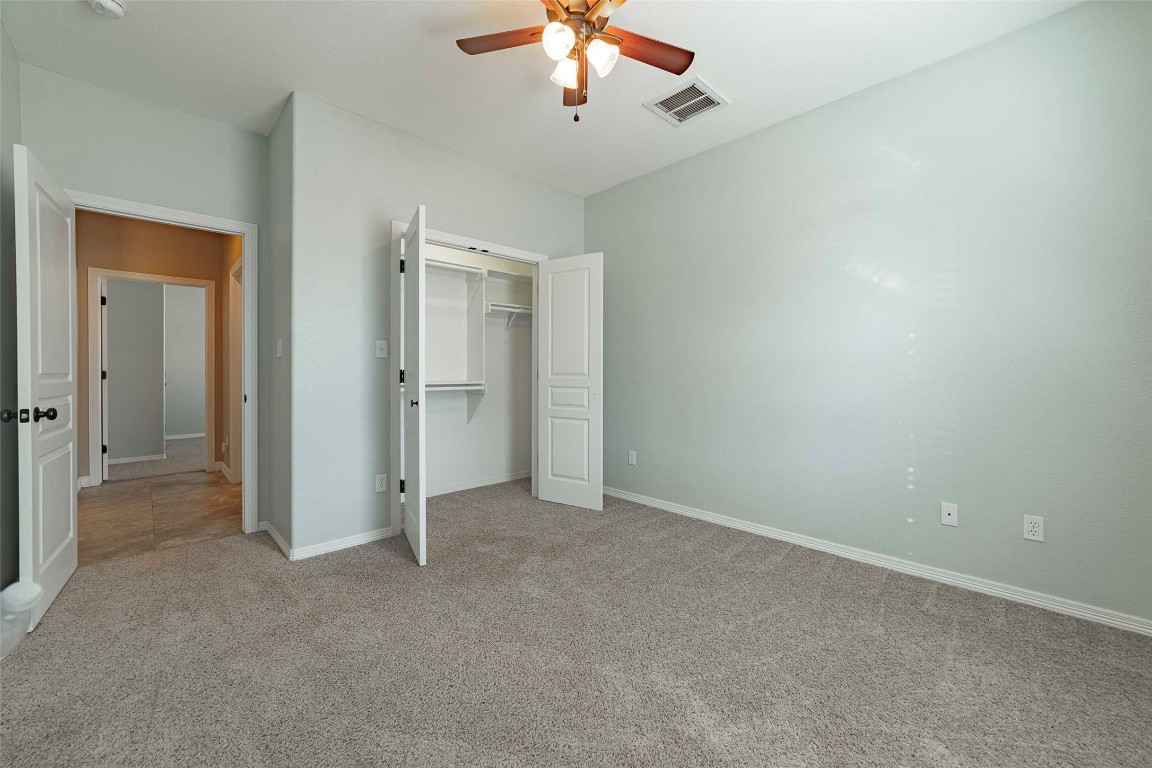 125 Walter Way Jarrell, TX 76537 - Photo 30 of 40 Unfurnished bedroom with light carpet, ceiling fan, and a closet