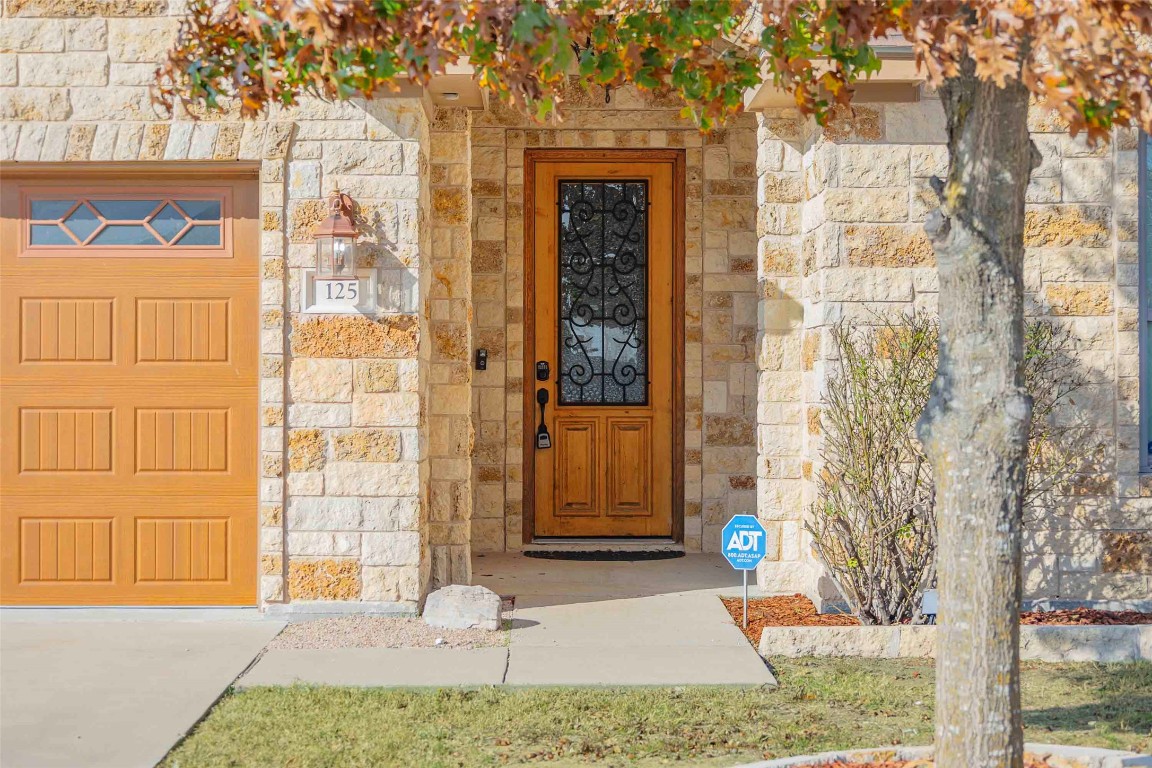 125 Walter Way Jarrell, TX 76537 - Photo 5 of 40 Doorway to property featuring stone siding and a garage