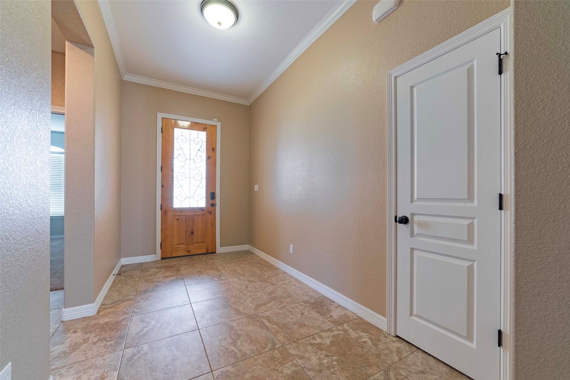 125 Walter Way Jarrell, TX 76537 - Photo 6 of 40 Foyer entrance with a textured wall and crown molding