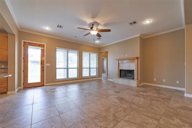 a view of an empty room with a fireplace and a window