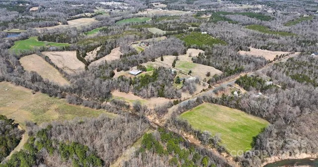 an aerial view of a house with a yard and lake view