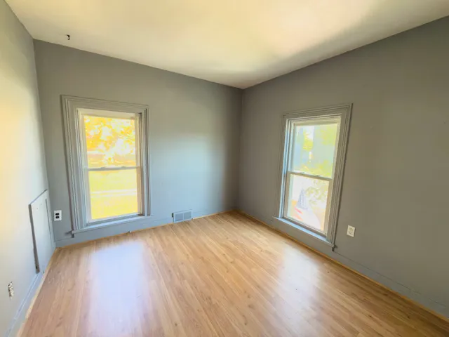 a view of a room with wooden floor and windows