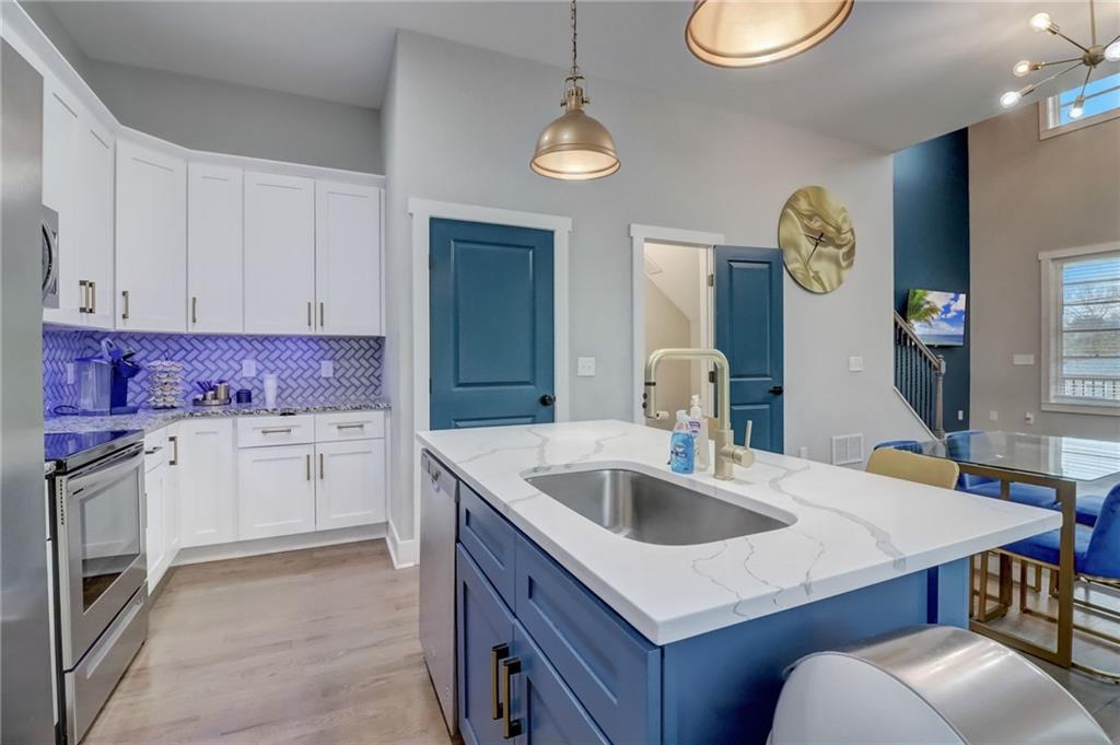 975 Welch Street Southwest Atlanta, GA 30310 - Photo 8 of 27 a kitchen with granite countertop a sink a stove and cabinets