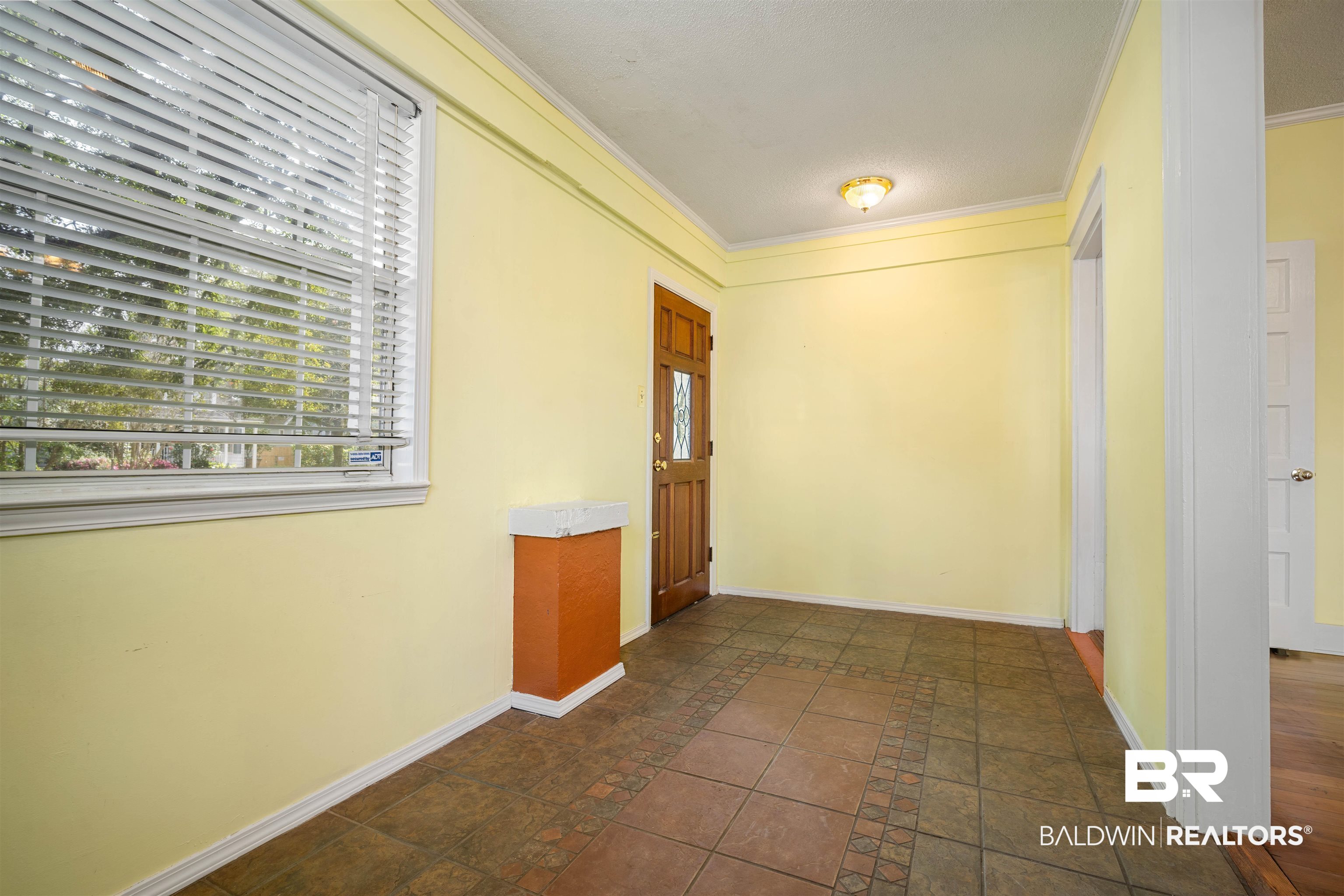 118 Mohawk Street Mobile, AL 36606 - Photo 21 of 26 Foyer with crown molding, inlaid floor details, and stone tile flooring