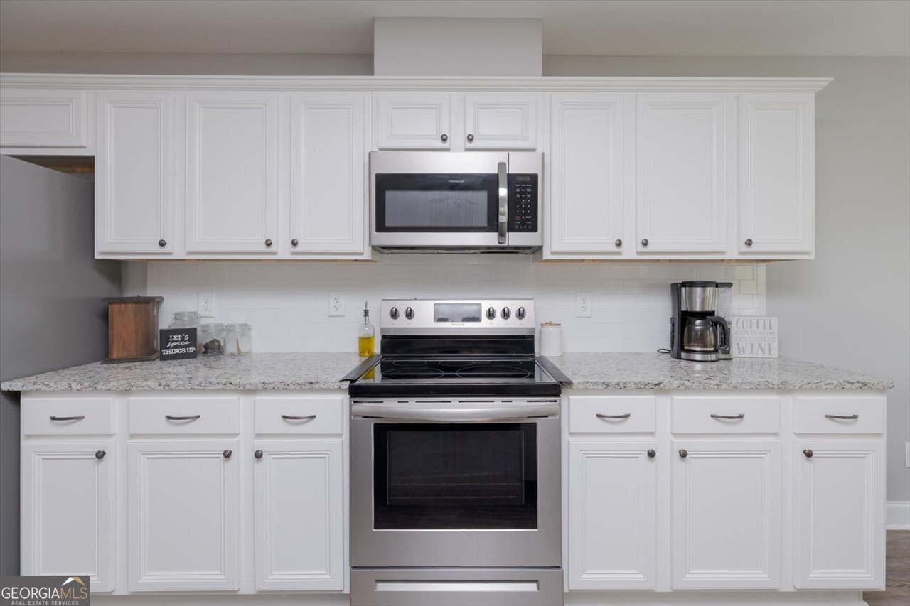 104 Meredith Layne Court Perry, GA 31069 - Photo 15 of 46 a kitchen with granite countertop white cabinets and stainless steel appliances