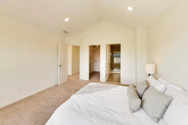 a spacious bedroom with a bed and a cabinets
