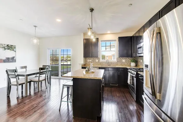 a kitchen with kitchen island granite countertop a sink stove and refrigerator