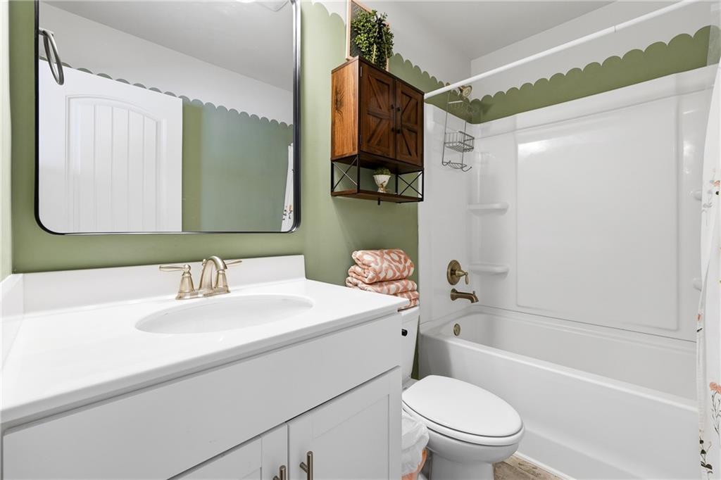 121 Treeline Trail Canton, GA 30115 - Photo 19 of 26 a bathroom with a sink a toilet a mirror a vanity and shower