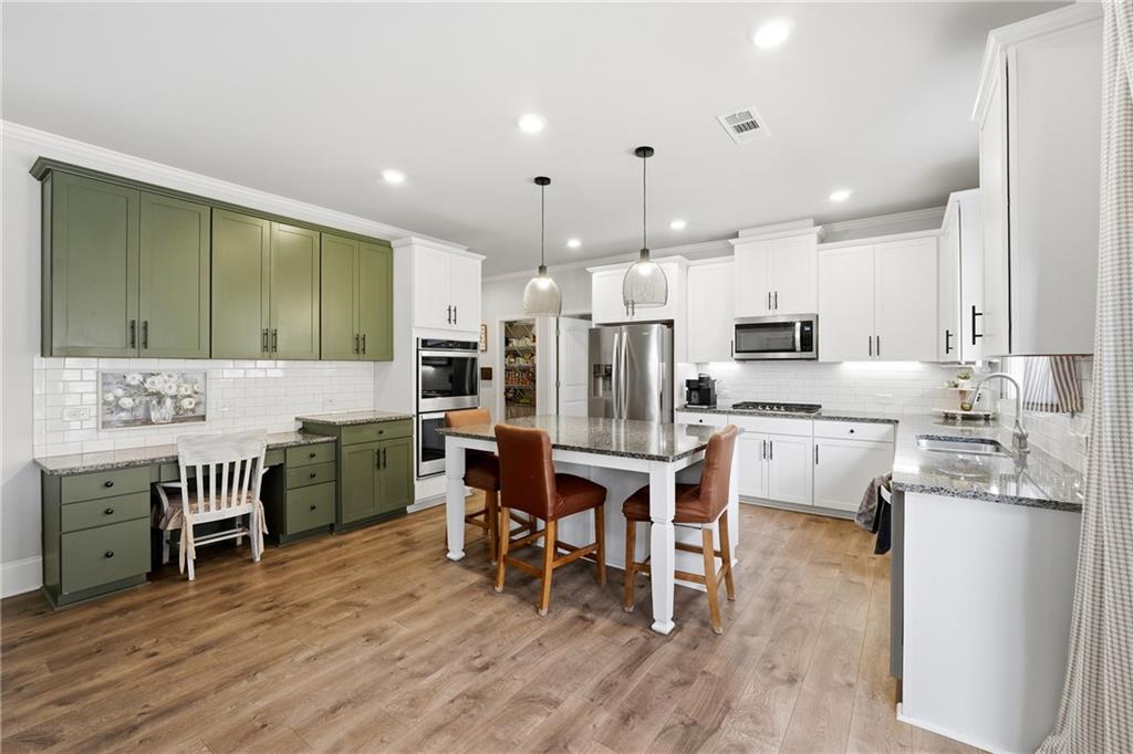 121 Treeline Trail Canton, GA 30115 - Photo 8 of 26 a kitchen with stainless steel appliances kitchen island granite countertop a table chairs sink and cabinets