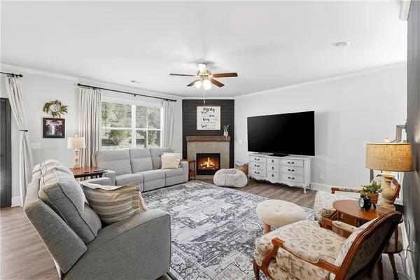 a living room with furniture a flat screen tv and a fireplace