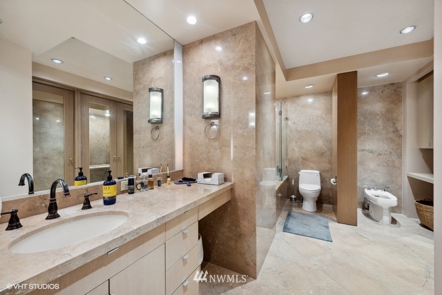 1301 Spring Street, Unit 30J Seattle, WA 98104 - Photo 15 of 40 a spacious bathroom with a double vanity sink toilet and a mirror