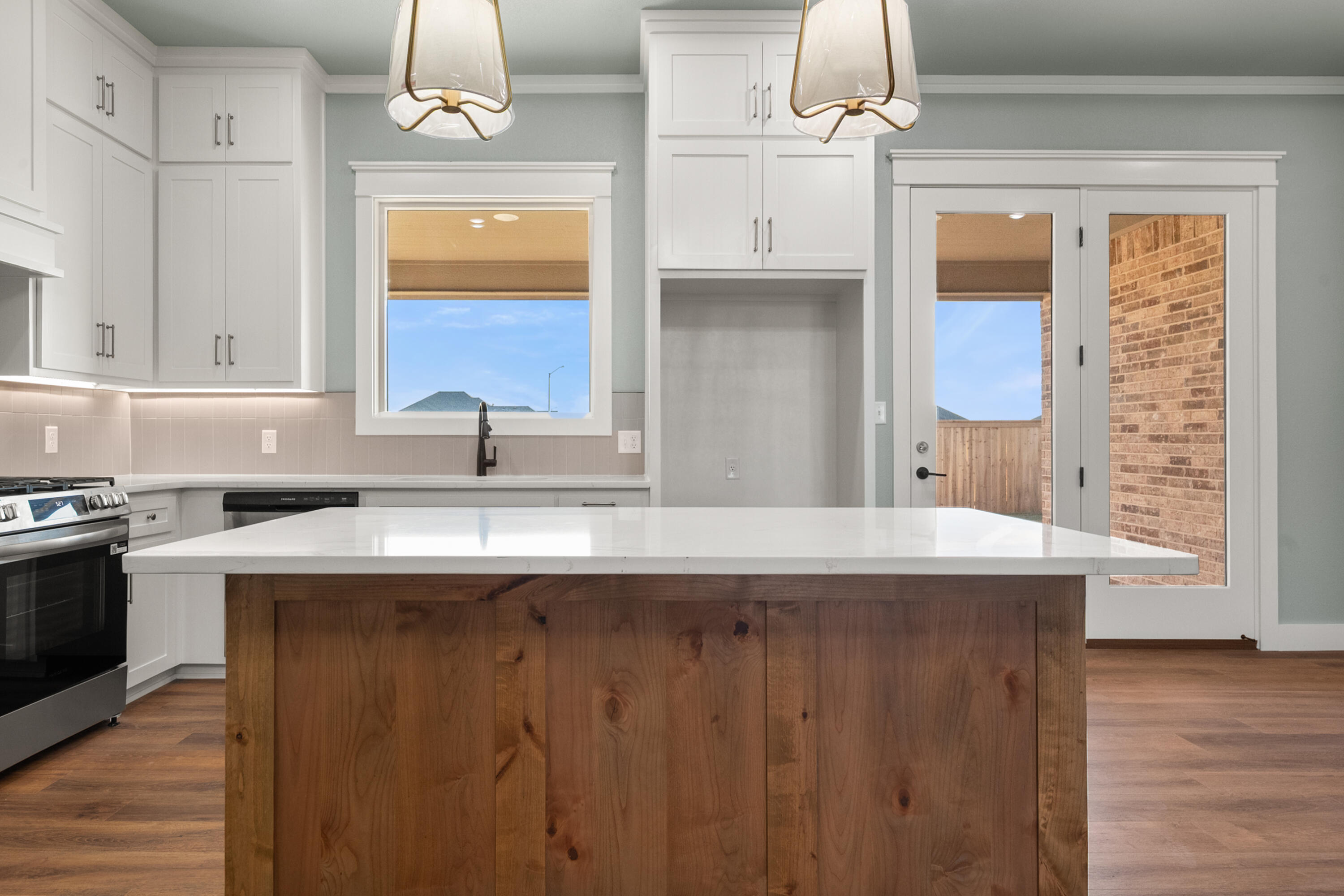 1121 North 6th Street Wolfforth, TX 79382 - Photo 11 of 31 a kitchen with cabinets a window and stainless steel appliances