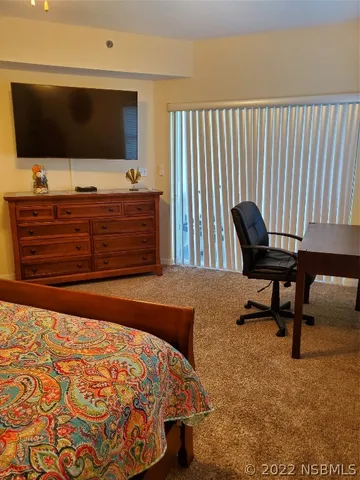 a bedroom with a bed and flat screen tv