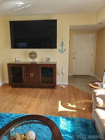 a living room with a flat screen tv a rug and a couch