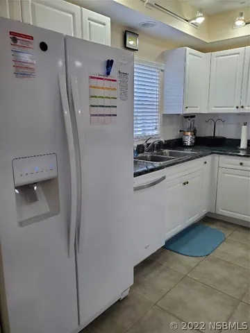 a kitchen with stainless steel appliances a refrigerator sink and white cabinets