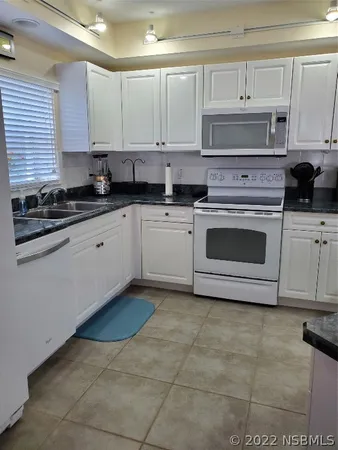 a kitchen with cabinets appliances and a window