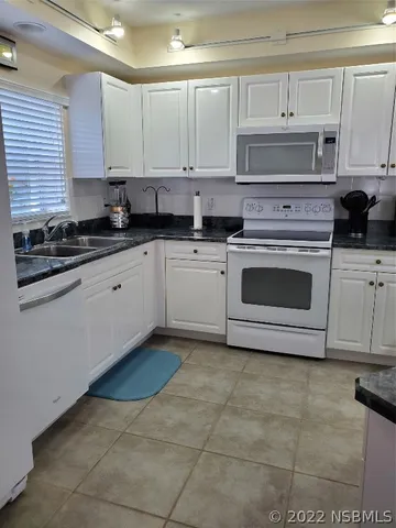 a kitchen with cabinets appliances and a window
