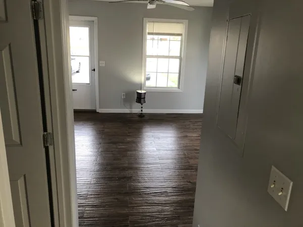 an empty room with wooden floor and windows