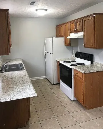a kitchen with a stove sink and cabinets