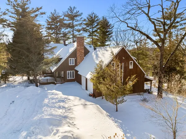 a view of a house with a yard covered with snow