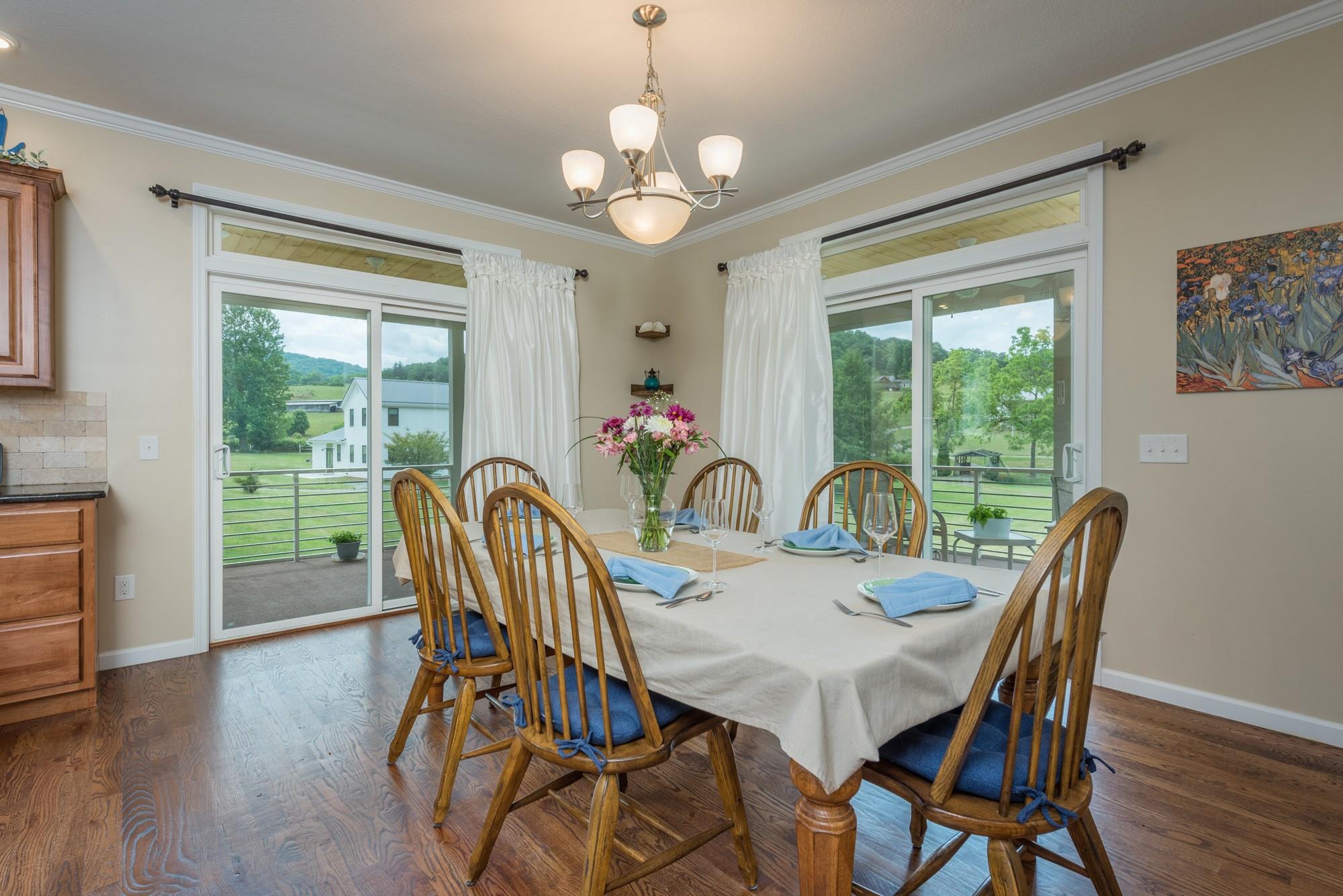 750 Iron Tree Drive Clyde, NC 28721 - Photo 29 of 40 a view of a dining room with furniture a chandelier and wooden floor