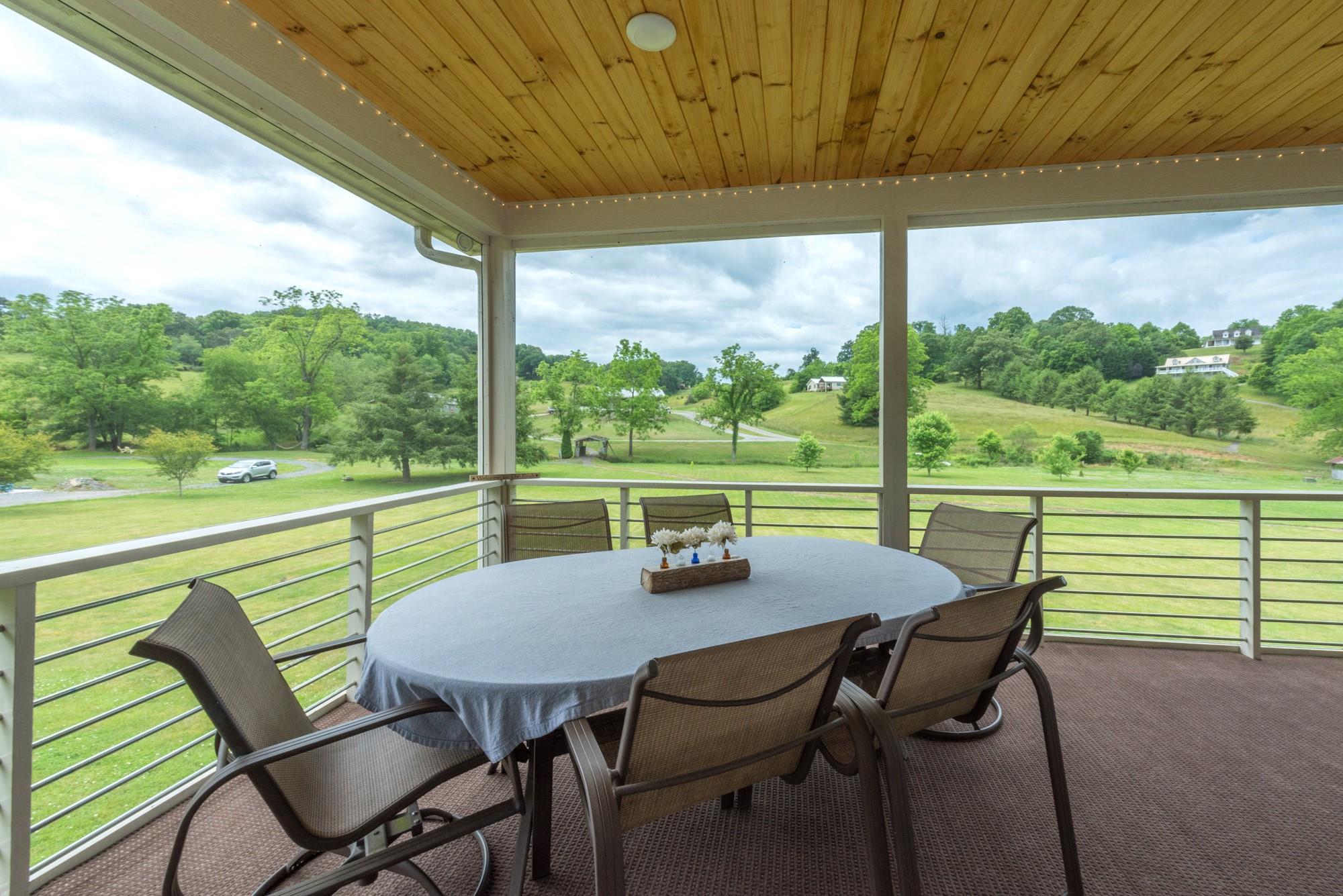 750 Iron Tree Drive Clyde, NC 28721 - Photo 3 of 40 a view of a patio with lawn chairs next to a yard
