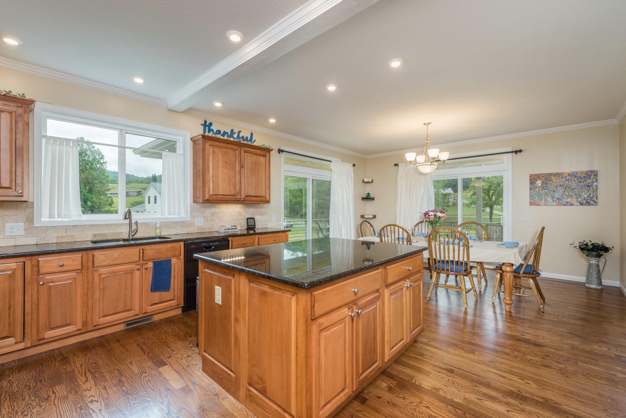 750 Iron Tree Drive Clyde, NC 28721 - Photo 31 of 40 a kitchen with stainless steel appliances granite countertop a stove and wooden cabinets