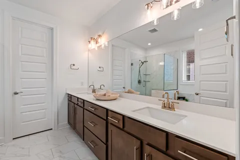 a bathroom with a double vanity sink a mirror and a bathtub