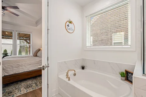 a bathroom with a tub sink and a window