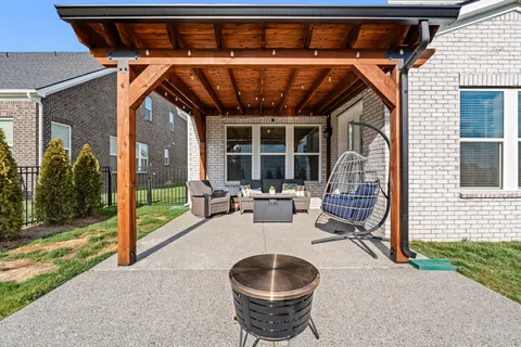 a patio with table and chairs and potted plants